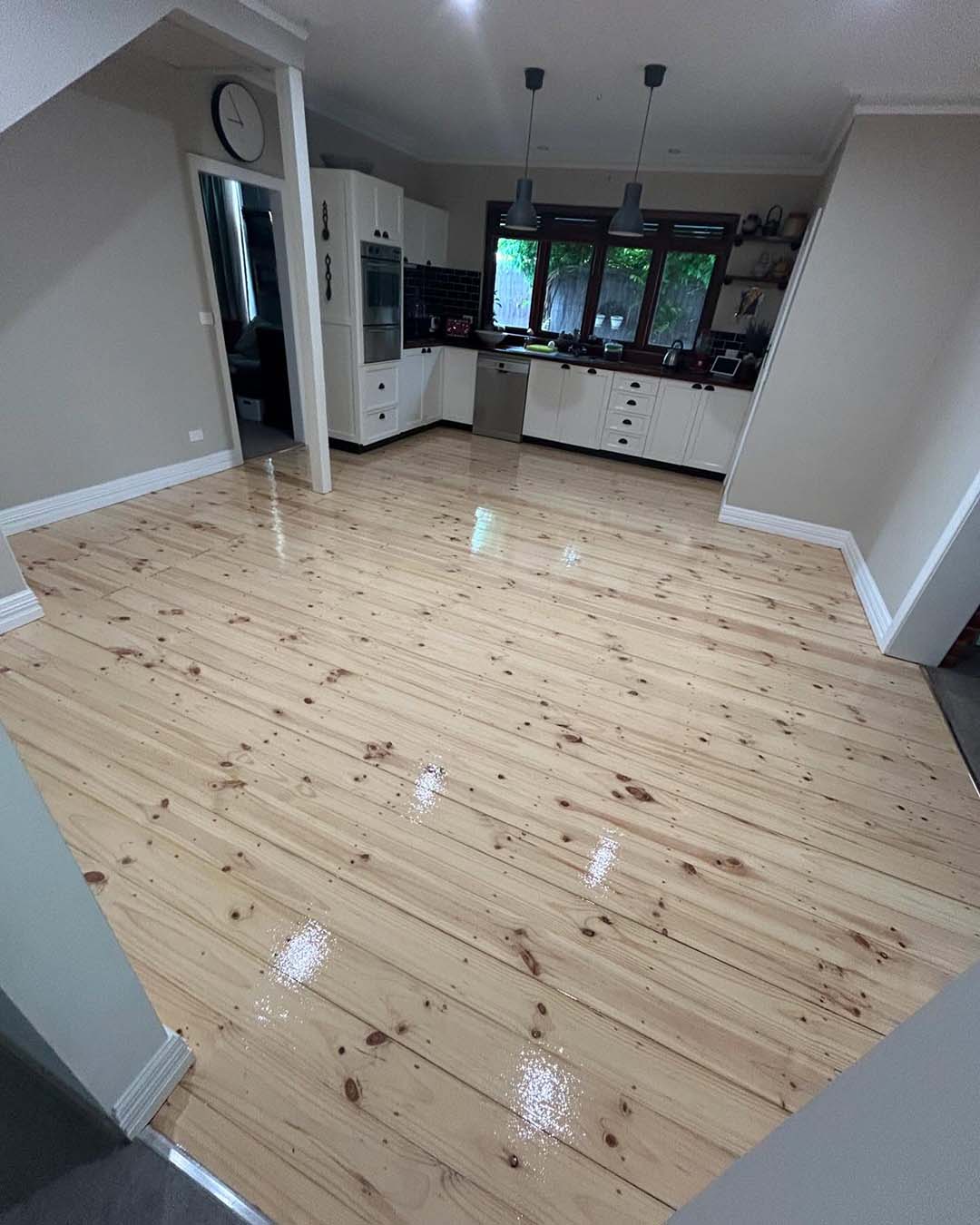 Glossy knotty timber floor in a kitchen and dining area