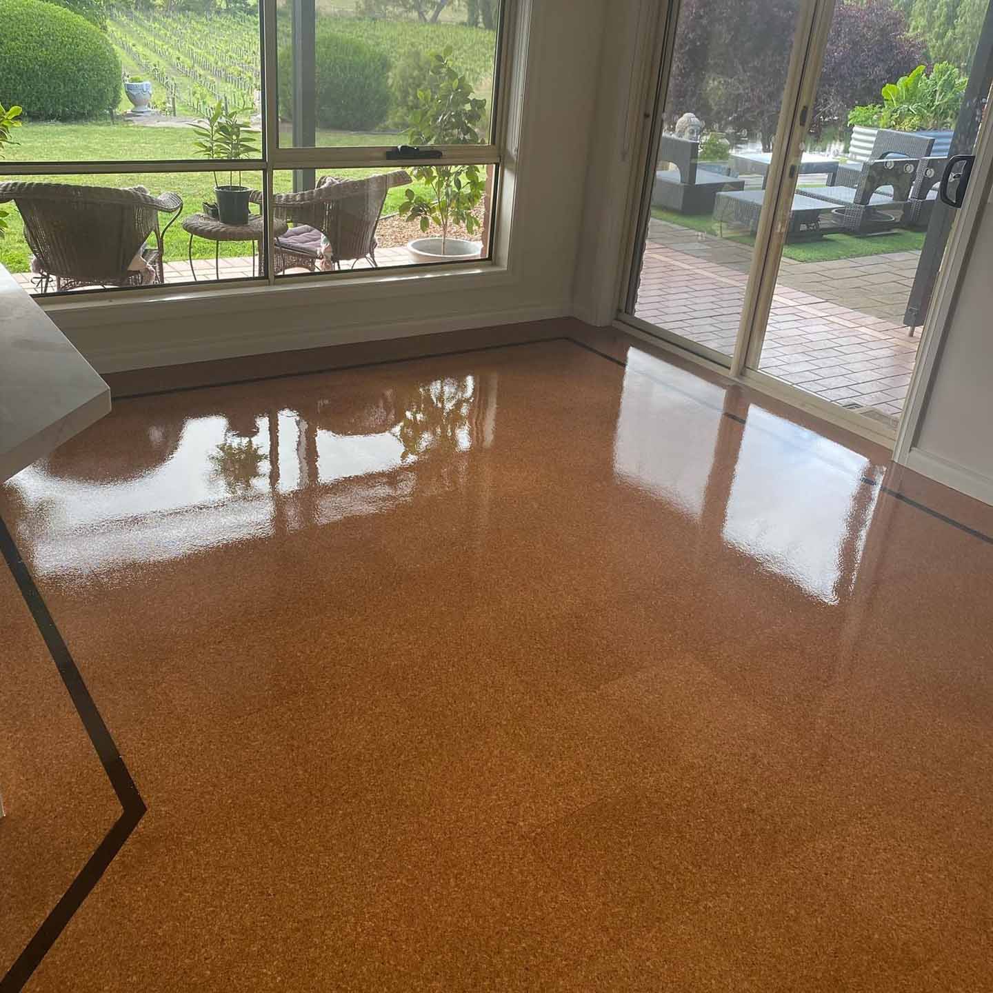 Glossy cork tile floor in a living room with doors to the garden